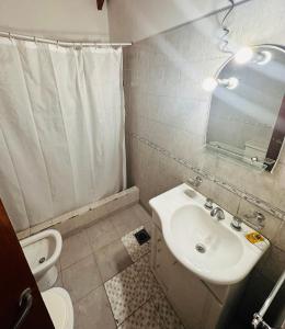 uma casa de banho com um lavatório, um WC e um espelho. em La carmencita Club de Campo em Ingeniero J. Allan