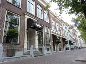 een bakstenen gebouw met een luifel op straat bij Hotel Royal Bridges in Delft