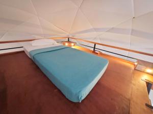 a small bed in a room with a wall at GeoLux - Luxurious Geodesic Dome in Chikmagalur