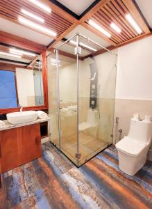 a bathroom with a glass shower and a toilet at GeoLux - Luxurious Geodesic Dome in Chikmagalur