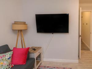 een woonkamer met een flatscreen-tv aan de muur bij 1 Ilsham Cottages in Torquay