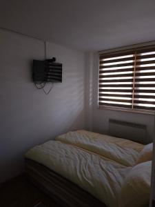 a bedroom with two beds and a television on the wall at KB Urban Apartment in Sarajevo +2 photos