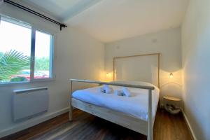 una camera da letto con un letto con cuscini blu e una finestra di Le Lovely - Appartement avec clim et piscine ! a Le Crès