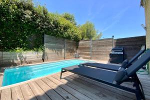 una piscina con panchina accanto di Le Lovely - Appartement avec clim et piscine ! a Le Crès
