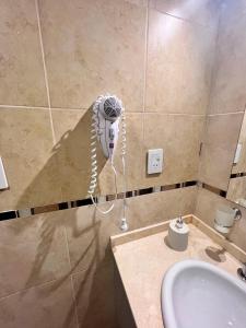 a bathroom with a phone hanging on the wall at Lumiere apartments 5- Departamento en complejo residencial in El Challao