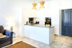 a kitchen with white cabinets and a counter top at Lovely Faro Apartment in Faro