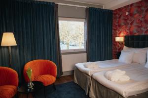 a hotel room with a bed and two chairs and a window at Quality Hotel Galaxen in Borlänge +64 photos