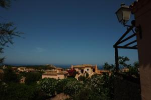 widok na wioskę z budynku z światłem ulicznym w obiekcie Calarossa Sardinia Apartments w mieście Isola Rossa