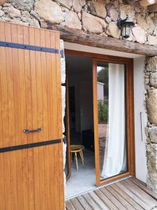 an open door to a room with a stone wall at Location Casa Di Lesia à Sotta / Porto-Vecchio in Sotta
