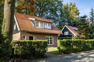 une maison en briques avec un toit rouge dans l'établissement 't Borghuis, à Losser