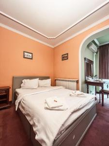 ein Schlafzimmer mit einem großen Bett mit orangefarbenen Wänden in der Unterkunft Pensiunea Curtea Bavareza in Târgu Mureș