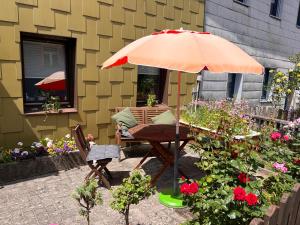una mesa y una silla bajo una sombrilla en un jardín en Gästehaus „Bei Emmi“, en Lichtenberg