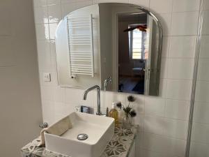 een witte badkamer met een wastafel en een spiegel bij So Paris Group - Fully Serviced Apartment - Jardin des Plantes - Heart of Paris in Parijs