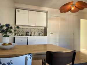 a kitchen with a table with a bowl of fruit on it at So Paris Group - Fully Serviced Apartment - Jardin des Plantes - Heart of Paris in Paris +12 photos