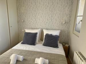een slaapkamer met een bed met 2 kussens bij So Paris Group - Fully Serviced Apartment - Jardin des Plantes - Heart of Paris in Parijs