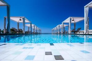 una piscina con sillas y el océano en el fondo en Zaton Holiday Resort Glamping Tents en Nin