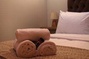 una pila de toallas sentadas encima de una cama en Δρυάδες Suites, en Arachova