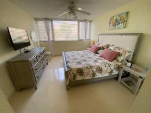 a bedroom with a bed and a dresser and a television at Moon Bay Condo, Paradise Found in Sunny Key Largo, Florida in Key Largo