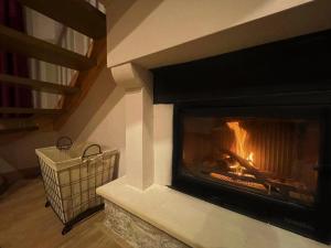 a fireplace in a living room with a fire in it at Δρυάδες Suites in Arachova