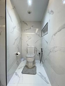 a white bathroom with a toilet and a shower at TANGIER City Centre Residence HILTON in Tangier