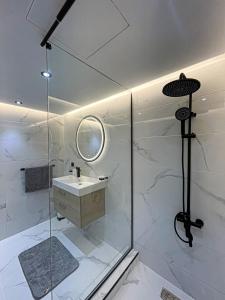 a bathroom with a shower with a sink and a mirror at TANGIER City Centre Residence HILTON in Tangier