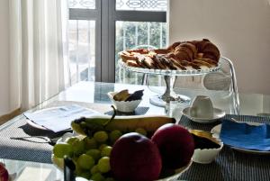 un tavolo di vetro con un cesto di frutta e un piatto di pane di Nisí a Crotone