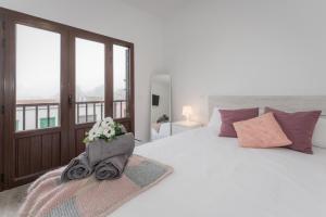 a bedroom with a large white bed with flowers on it at Buena Vista House by Canarias Homelidays in Santa Brígida