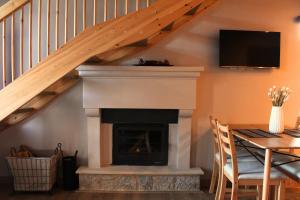 a living room with a fireplace and a staircase at Δρυάδες Suites in Arachova