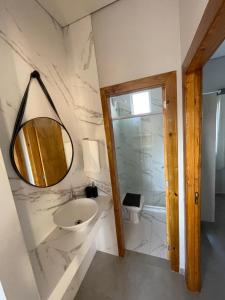 a bathroom with a sink and a mirror at Vila do Rosa in Praia do Rosa
