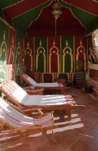 une chambre avec des chaises et des peintures sur les murs dans l'établissement Appartement Andalou, à Marrakech
