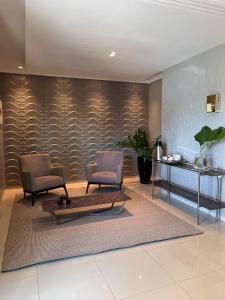 two chairs and a table in a room with a wall at FLORENÇA PALACE HOTEL in Lucas do Rio Verde