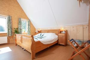 1 dormitorio con cama de madera y silla de madera en Vegan B&B De Groene Mus, en Wervershoof