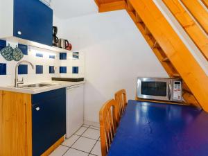 uma cozinha com uma mesa azul e um micro-ondas em Villa Gruissan, 2 pièces, 5 personnes - FR-1-409-9 em Gruissan