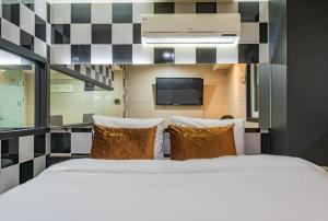 1 dormitorio con 1 cama grande y TV en la pared en S plus motel en Geoje 