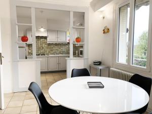 Una cocina blanca con una mesa y sillas blancas. en The Reverdy, en Chartres