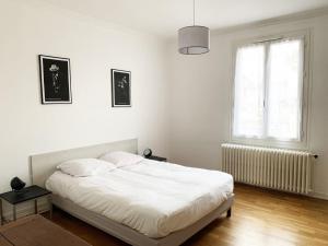 Un dormitorio blanco con una cama y una ventana. en The Reverdy, en Chartres