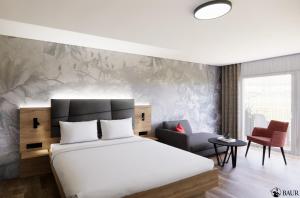 Bischoffingen的住宿－石頭降壓頂級酒店，配有一张床和一把椅子的酒店客房