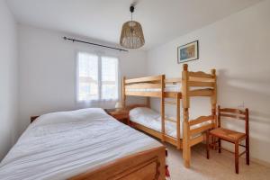 Ένα ή περισσότερα κρεβάτια σε δωμάτιο στο Maison pour 8 - 5min de la plage - jardin & véranda