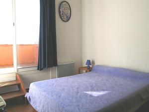 um quarto com uma cama e um relógio na parede em Appartement Marseillan-Plage, 2 pièces, 6 personnes - FR-1-387-48 em Marseillan