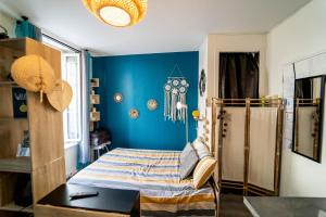 a bedroom with a bed and a blue wall at Double Appart Hypercentre Blois in Blois