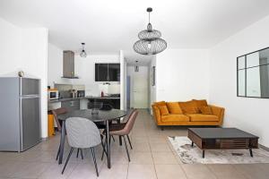 una cucina e un soggiorno con tavolo e divano di Le Juvignacois- 2 bedrooms and large terrace a Juvignac