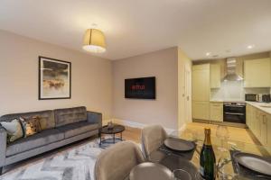 een woonkamer met een bank en een tafel bij Modern 2 Bed Ground Floor - Private Parking in Windsor