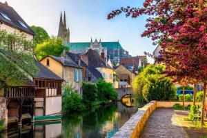 Le Nid - Chartres Cœur de ville في شارتر: مدينة فيها نهر ومباني وجسر