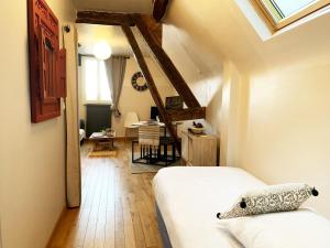 Le Nid - Chartres Cœur de ville في شارتر: غرفة نوم مع سرير وغرفة طعام