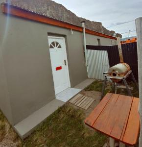 un pequeño cobertizo con una puerta y un banco en Don Galle en El Chaltén