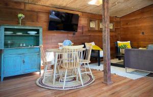 a living room with a table and chairs and a tv at Casa Ayacara in Frutillar