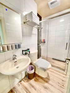 a bathroom with a sink and a toilet and a shower at Banshan Yunxiu Homestay in Jinning