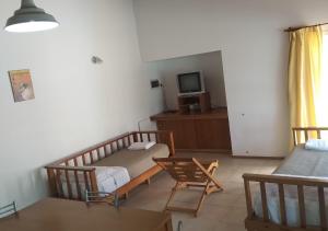 a room with a bed and a table and a tv at Complejo El Peregrino in Cortaderas