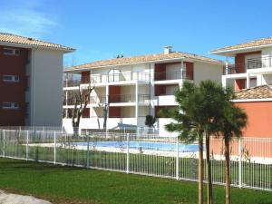 un complexe d'appartements avec une piscine et une clôture dans l'établissement Appartement Marseillan-Plage, 2 pièces, 4 personnes - FR-1-387-74, à Marseillan