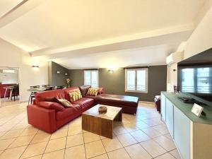 ein Wohnzimmer mit einem roten Sofa und einem Tisch in der Unterkunft CC OT La Maison de Paule OLD TOWN PROMENADE DES A in Nizza